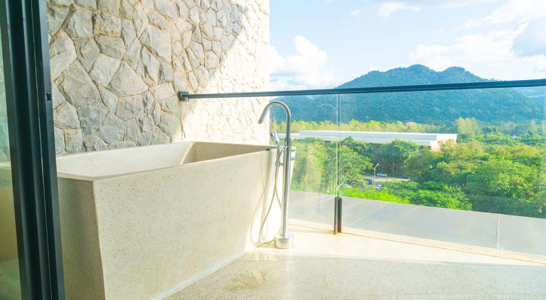 magnifique baignoire sur un balcon avec garde corps en verre