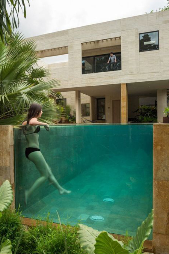 Un mur de piscine en verre avec vue sur le jardin